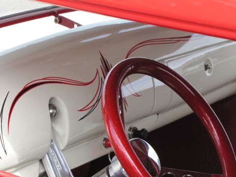 2006 BMW 5 Series - Interior view of a custom hot rod a white dashboard with pinstripe graphics and a metallic red steering wheel.