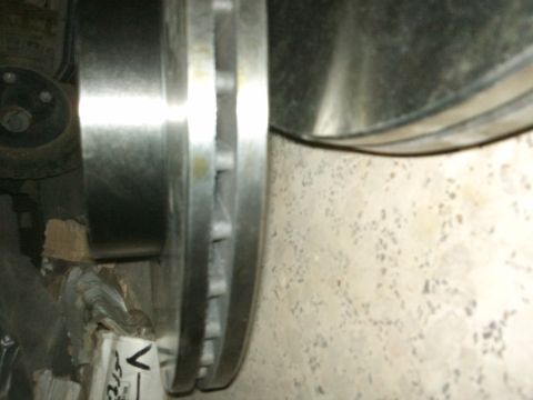 1998 Ford Crown Victoria - A close-up view of a car's brake rotor and part of the caliper is visible, with some packaging material in the background.