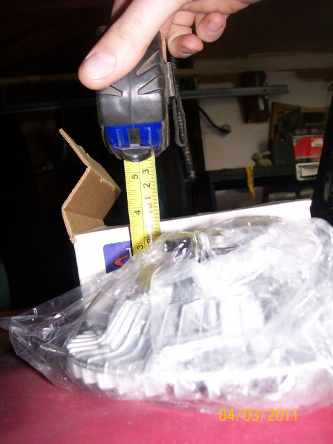 1970 Ford Bronco - A tape measure is used to check the dimensions of a part packaged in plastic.