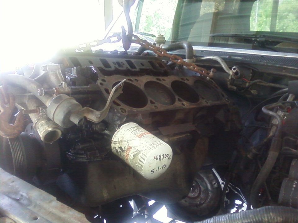 Rusty inline engine block exposed in an open engine bay