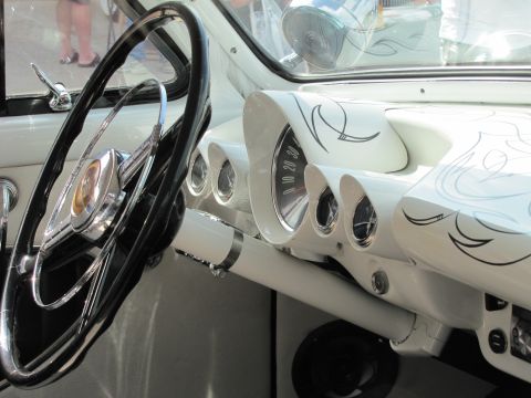 2006 BMW 5 Series - The interior of a classic car features a white dashboard adorned with pinstripes, a large steering wheel, and multiple gauges.