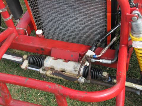 2006 BMW 5 Series - Close-up view of the steering rack and radiator components on a red racing vehicle.