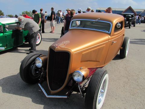 2006 BMW 5 Series - A custom hot rod with whitewall tires is displayed at an outdoor car show.