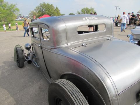 2006 BMW 5 Series - A custom hot rod coupe with a brushed metal finish is parked outdoors at an event.