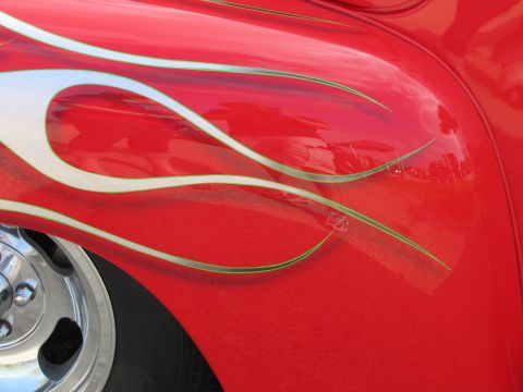2006 BMW 5 Series - Close-up of a red car's side panel custom silver and green flame graphics and a chrome wheel.