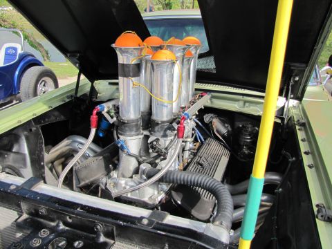 2006 BMW 5 Series - Custom V8 engine with chrome stacks and orange air filters is visible in a light green car, with another blue vehicle in the background.