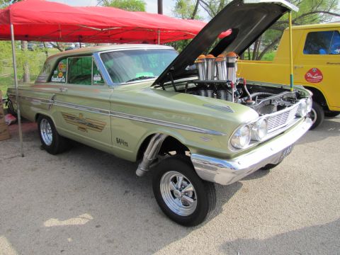 2006 BMW 5 Series - A customized vintage Ford Fairlane drag car is displayed with its hood up, revealing a powerful engine and custom exhaust pipes.