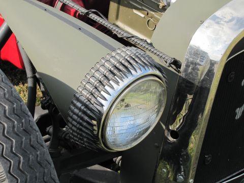 2006 BMW 5 Series - A close-up view of a vehicle's headlight, uniquely decorated with a band of bullets.