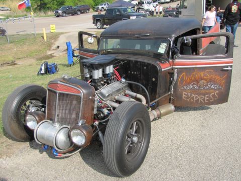 2006 BMW 5 Series - This custom rat rod features an exposed V8 engine and unique "Custom Speeds Express" lettering on its door.