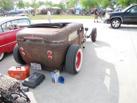 2006 BMW 5 Series - A custom-built rat rod hot rod with a weathered exterior and prominent exhaust pipes is displayed at an outdoor event.