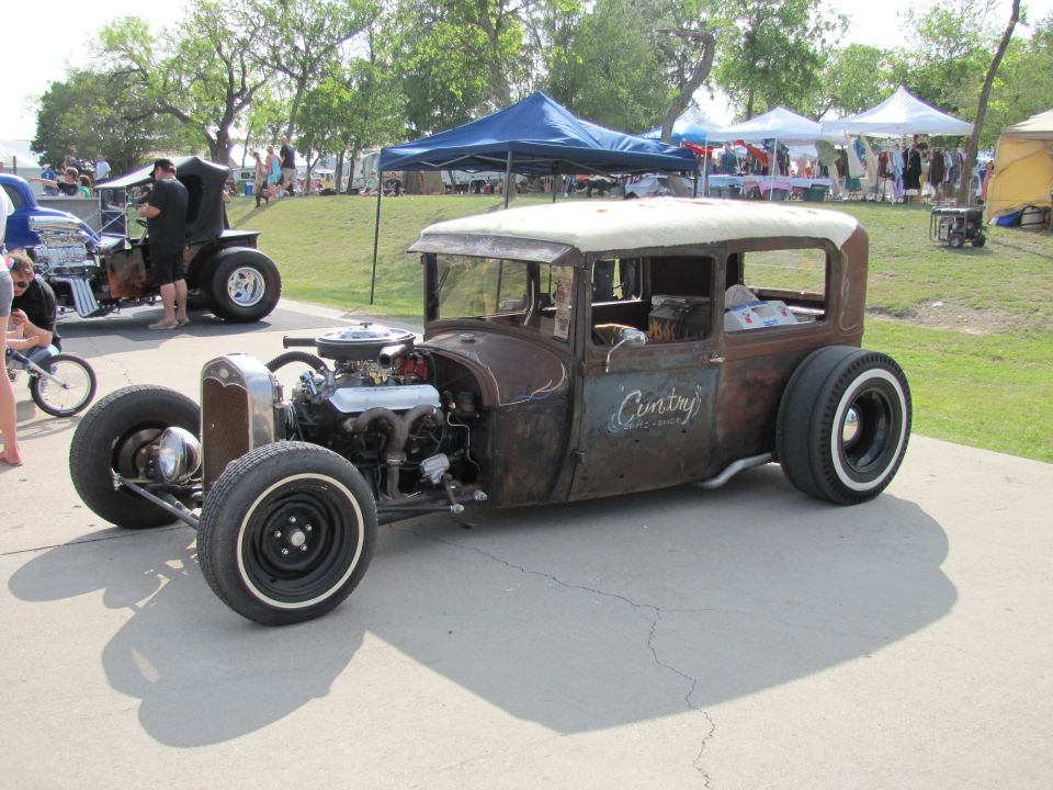 Rusty hot rod with whitewall tires and exposed engine