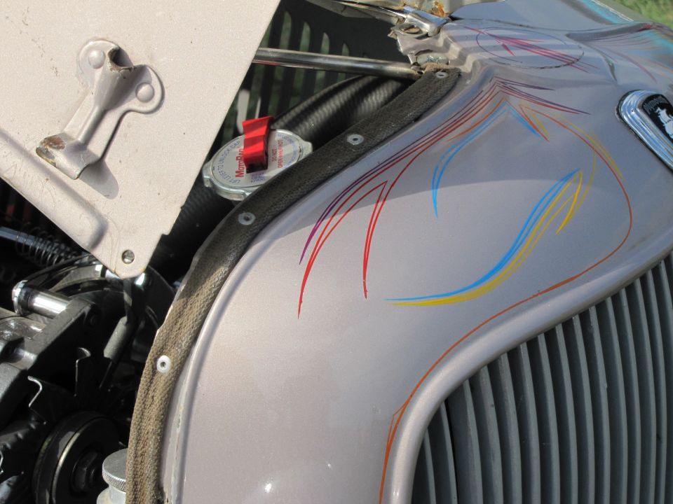 Silver hood with red, blue, and yellow pinstripes and vertical grille
