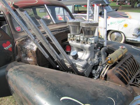 2006 BMW 5 Series - A heavily modified hot rod displays its custom engine and exhaust system, with another vehicle visible behind it.