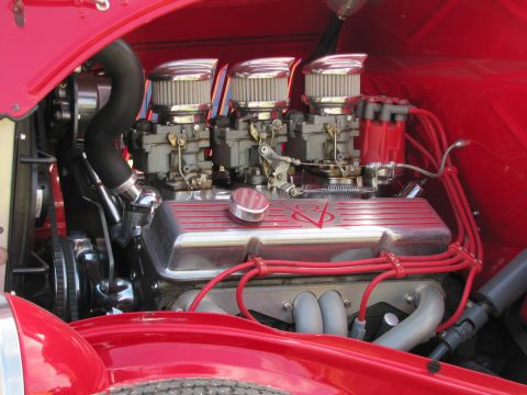 2006 BMW 5 Series - The engine bay of a classic car features a V8 engine with multiple carburetors and bright red spark plug wires.