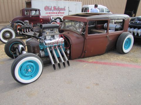 2006 BMW 5 Series - A custom hot rod with a powerful engine sits parked next to other vehicles.