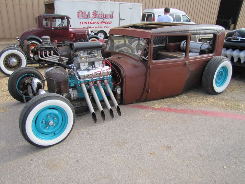 Brown hot rod car with exposed engine and turquoise wheels