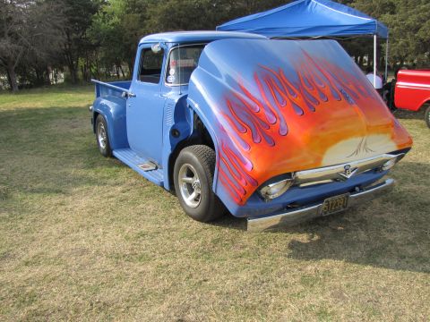 2006 BMW 5 Series - A classic blue pickup truck is parked on grass with its hood open, revealing custom flame artwork.