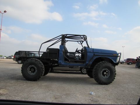 2006 BMW 5 Series - A custom blue buggy with a roll cage and oversized tires sits in a parking lot under a cloudy sky.