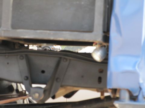 2006 BMW 5 Series - The underside of a truck chassis is visible, with a hint of another vehicle in the distance.