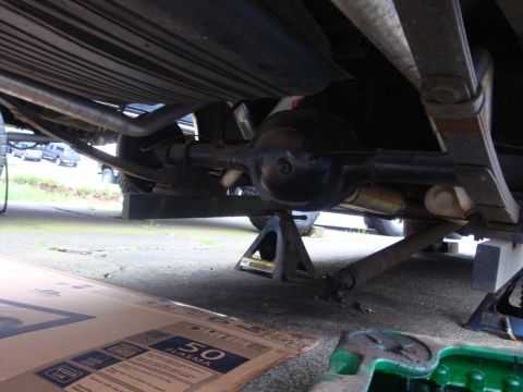 1964 Ford Fairlane - Vehicle's rear axle and suspension components are visible while supported by jack stands.