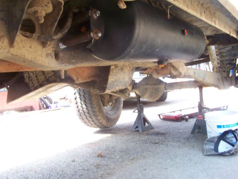1989 Ford Bronco - The underside of a 1989 Ford Bronco shows an aftermarket tank, likely for auxiliary fuel or air, mounted between the frame rails.