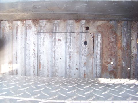 1989 Ford Bronco - Interior of a heavily rusted truck bed, showing corrugated metal walls and diamond plate flooring.