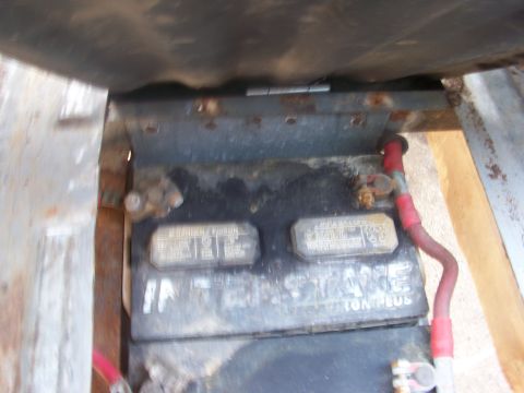 1989 Ford Bronco - A close-up view of a car battery, showing its terminals and some signs of wear.