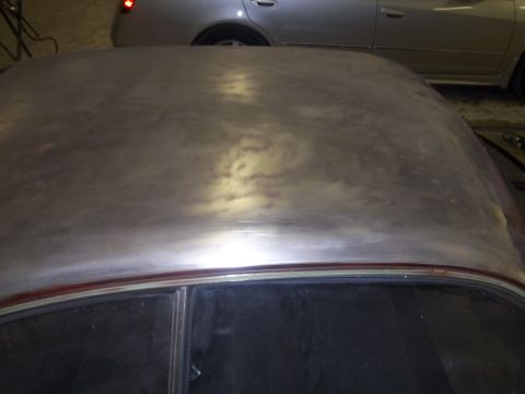 1971 Dodge Dart - The bare metal roof of a car is visible, with a red trim line above the window. Another car is seen in the background.