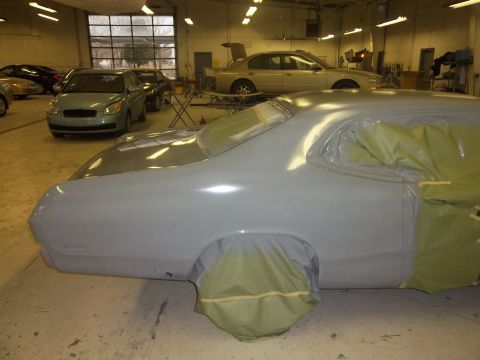 1971 Dodge Dart - Car body in primer, masked for paint, in a garage with other vehicles.
