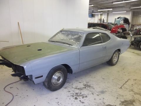 1971 Dodge Dart - A gray Dodge Dart coupe in primer sits in a workshop, awaiting restoration.