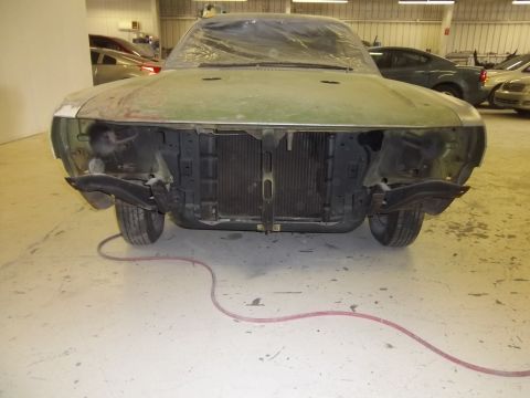 1971 Dodge Dart - A car undergoing repairs or restoration in a workshop setting, with other vehicles in the background.