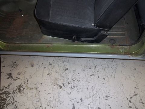 1971 Dodge Dart - Interior view of a car's door sill and seat, with visible rust and wear on the floor.