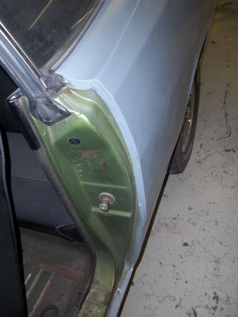 1971 Dodge Dart - Close-up view of a car's door jamb, showing the transition from green interior paint to gray primer on the exterior panel.