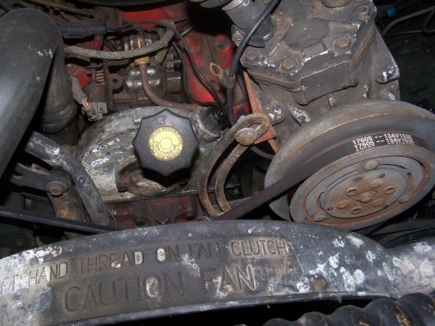 1989 Ford Bronco - Close-up view of an engine compartment, showing various mechanical components and warning labels.