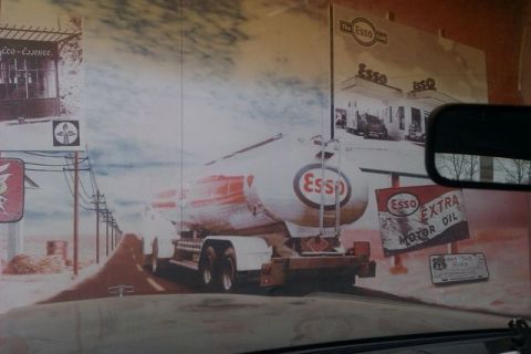 1991 Ford LTD Crown Victoria - This photo shows a mural depicting a vintage Esso gas station scene, complete with a tanker truck and old advertisements.