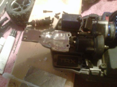 2011 Ford 427 - Close-up of disassembled RC car components, including suspension and drivetrain parts.