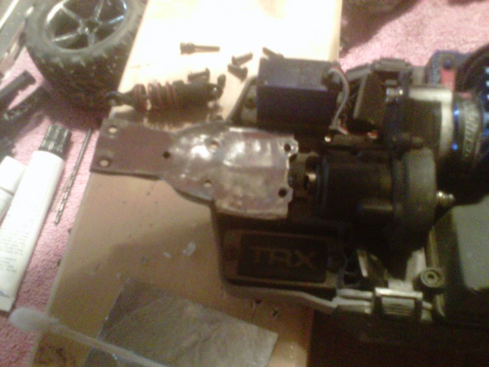 Disassembled Traxxas TRX radio-control car chassis and parts on a workbench