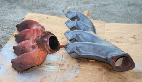 1976 Ford Ranchero - Pair of exhaust manifolds, one showing significant rust and the other appearing to be painted.