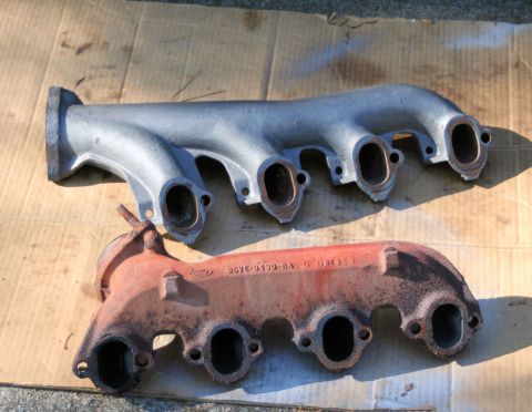 1976 Ford Ranchero - Two exhaust manifolds are shown, one in a rusty red finish and the other in a silver finish.