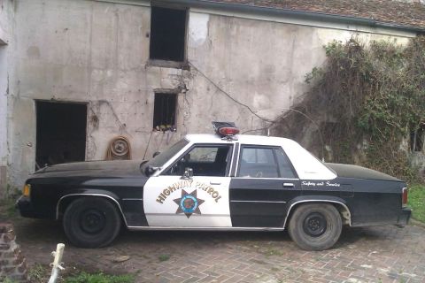 1991 Ford LTD Crown Victoria - A 1991 Ford Crown Victoria police car with 'Highway Patrol' markings is seen from the side.