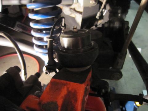 2008 Jeep Wrangler - A detailed view of a vehicle's suspension system, focusing on a ball joint and coil spring.