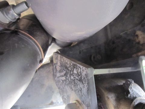 2008 Jeep Wrangler - Underside view of an exhaust pipe and a metal bracket, likely part of a vehicle's exhaust system.