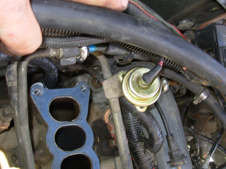 As soon as the spark plug wire was fixed, the engine started surging, which eventually turned out to be a leaking FPR.  Big surprise - it was a 21-year-old junkyard part, but he still got his money's worth out of it.  So while I was changing it, I also replaced the PCV valve, hose, grommet, and fitting on the plenum.  I also replaced several other vacuum lines.

The PCV is dead-center at the rear of the intake.