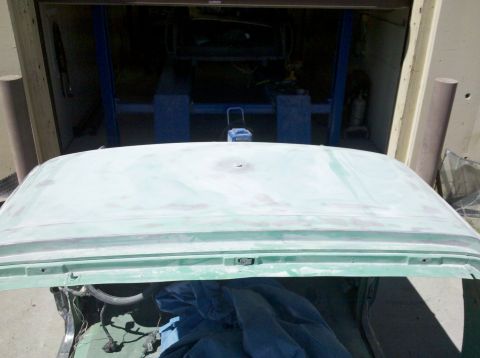 1995 Ford Bronco - The car roof is covered in primer, with a visible hole and green trim below.