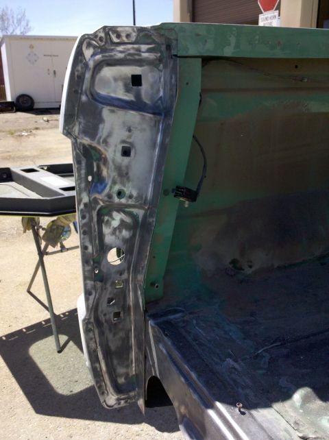 1995 Ford Bronco - A vehicle body panel is shown with paint being stripped, revealing the underlying metal and primer. The context suggests it's part of a lar…