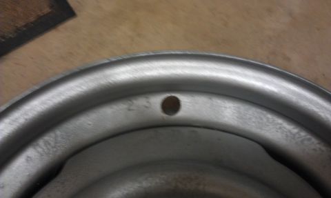 1965 Ford Mustang - Close-up view of a steel wheel rim, showing the numbers '23' stamped near a bolt hole.