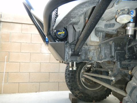 1997 Ford Ranger - Low-angle view under the front of a lifted silver truck showing a bare-metal front bumper/skid plate bolted to the frame horns, a black tub…