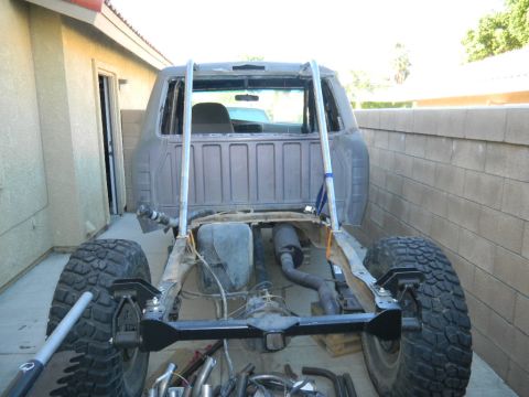 1997 Ford Ranger - Rear view of a gray pickup with the bed removed, showing the exposed frame rails, fuel tank, muffler and exhaust routing, plus a freshly pa…