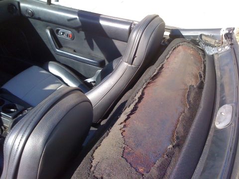 1991 Mazda Miata - Interior view of a 1991 Mazda Miata, highlighting the damaged soft top and seats.