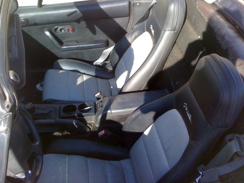 1991 Mazda Miata - The interior of a 1991 Mazda Miata shows its two-tone seats and manual transmission.
